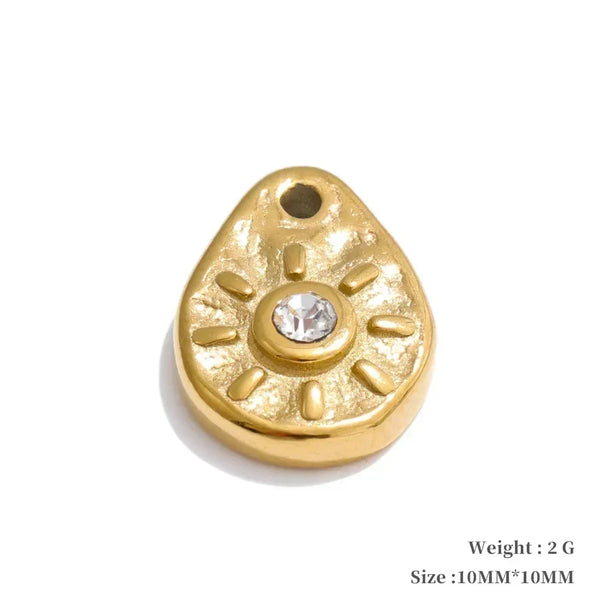Gold teardrop-shaped pendant with a central gemstone on a white background
