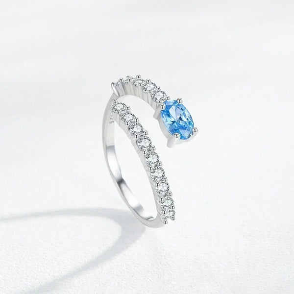 Silver ring with a blue gemstone on a light gray background