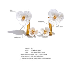 White flower-shaped earrings with gold accents on a white background