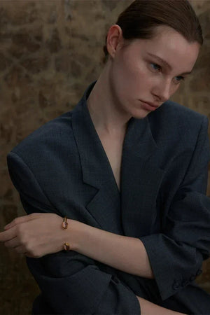 Woman wearing a dark gray blazer with a subtle background