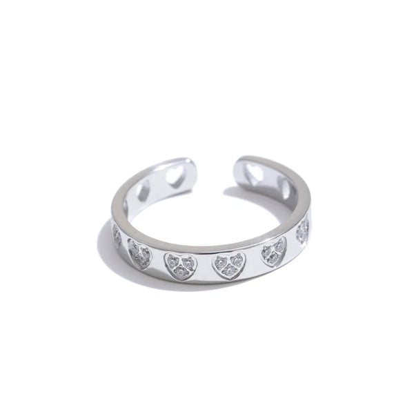 Silver ring with heart-shaped cutouts on a white background