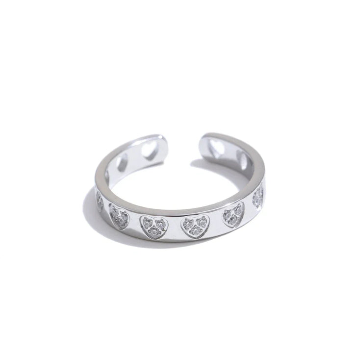 Silver ring with heart-shaped cutouts on a white background