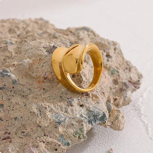 18K gold-plated knot design ring on textured stone, minimalist jewelry style