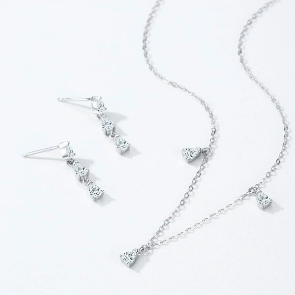 Silver necklace and earrings set on a white background