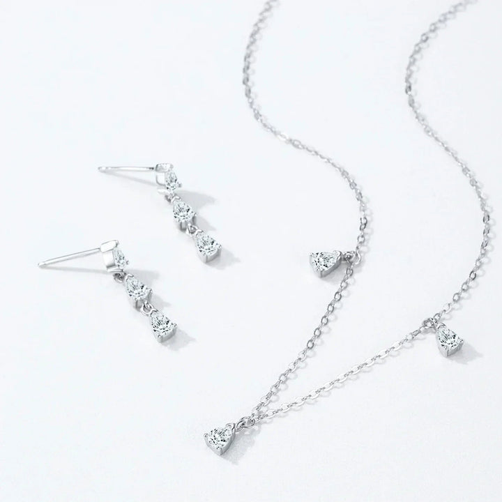 Silver necklace and earrings set on a white background