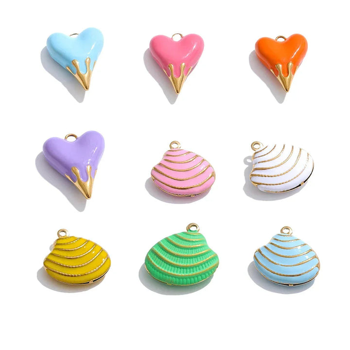 Colorful heart and shell-shaped charms with gold accents on a white background.