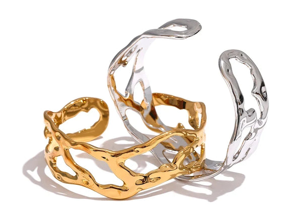 Gold and silver cuff bracelets on a white background