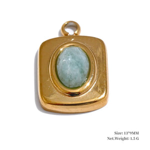 Gold pendant with a green gemstone on a white background