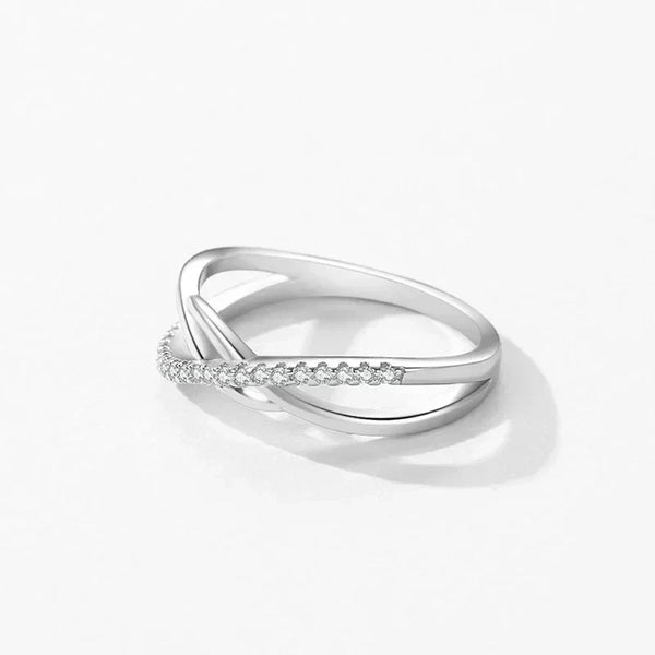 Elegant 925 silver crossover ring with sparkling pavé stones on a white background