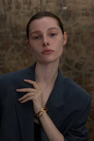 Woman wearing a dark blazer with a textured wall background