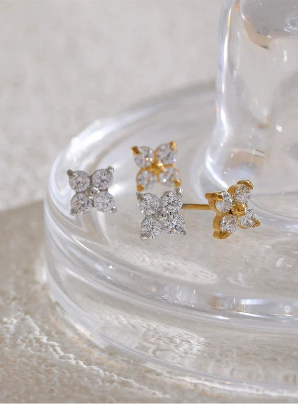 Butterfly-shaped earrings on a clear stand with a white background