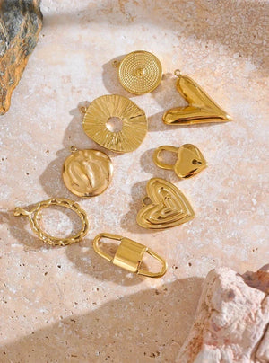 Gold jewelry pieces on a textured beige surface