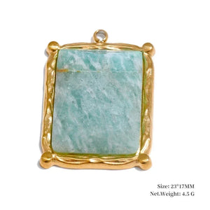 Gold-framed pendant with a green stone on a white background