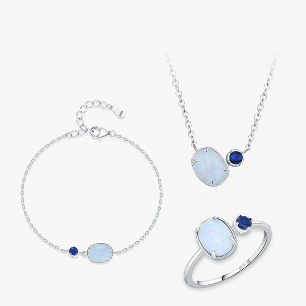 Silver jewelry set with opal and blue gemstones on a white background
