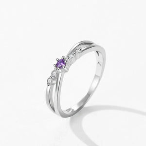 Silver ring with a purple gemstone on a white background