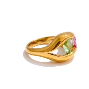 Gold ring with a multicolored gemstone on a white background