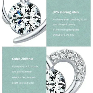 Silver earring with cubic zirconia stones on a light green background