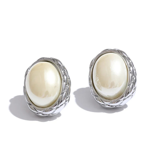 Pair of earrings with white oval stones and silver wireframe designs on a white background
