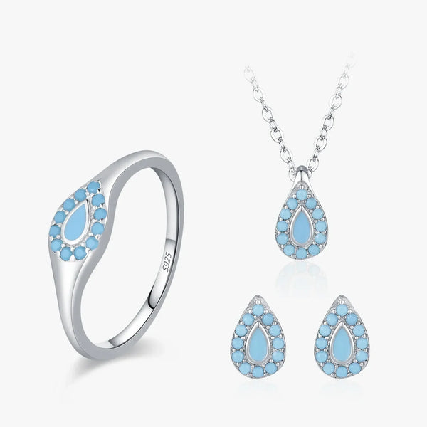 Silver jewelry set featuring a ring, pendant necklace, and matching earrings, each decorated with light blue teardrop-shaped stones surrounded by small clear stones, shown on a clean white background.
