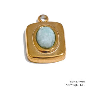 Gold pendant with a green stone on a white background