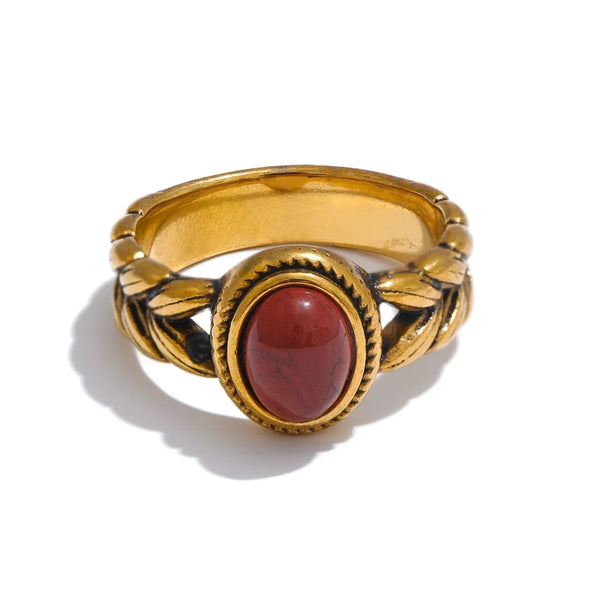 Gold ring with a red stone on a white background
