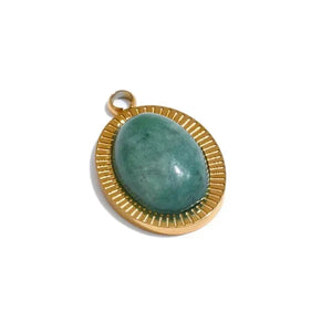 Gold pendant with a green stone on a white background