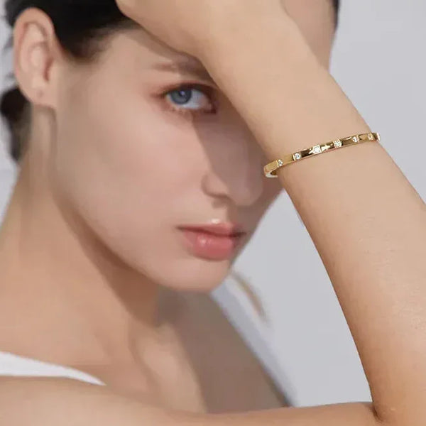 Woman wearing a minimalist 18K gold-plated textured bracelet on her wrist