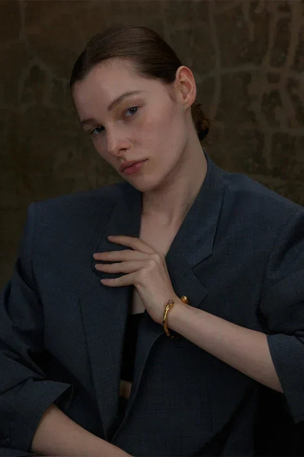 Woman wearing a dark blue blazer against a textured brown background