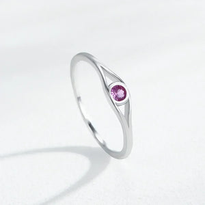 Silver ring with a pink gemstone on a light gray background