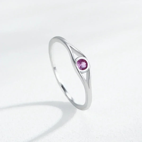 Silver ring with a pink gemstone on a light gray background