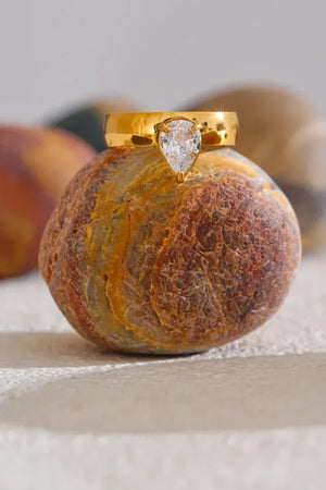 Gold ring with a diamond on a textured stone surface