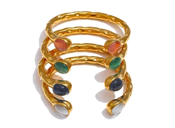 Set of gold rings with colorful gemstones on a white background