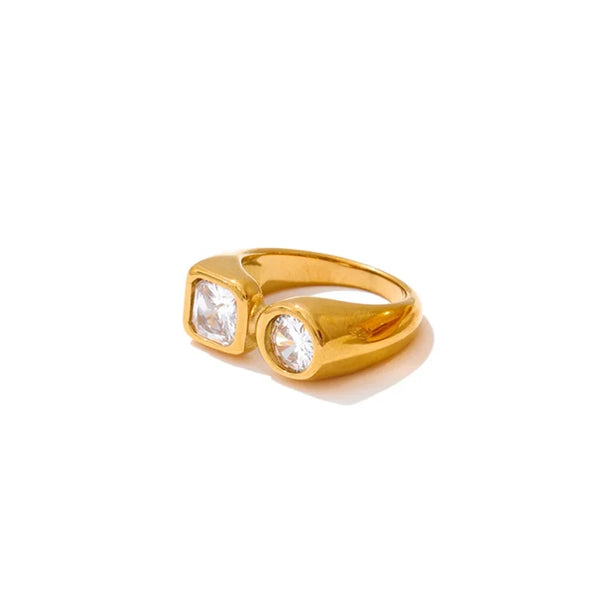 Gold ring with two clear gemstones on a white background