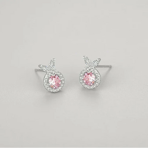 Pair of silver earrings with pink gemstones on a light gray background