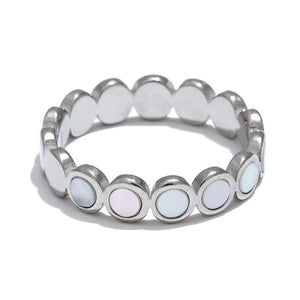 Silver ring with circular white stones on a white background