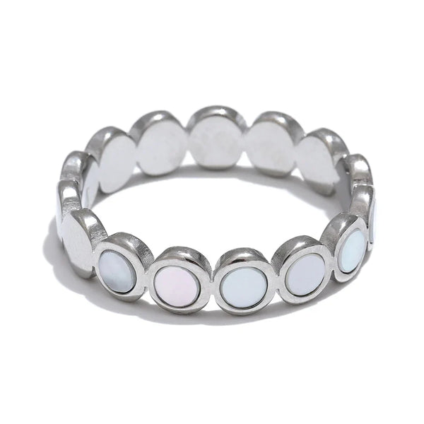 Silver ring with circular white stones on a white background