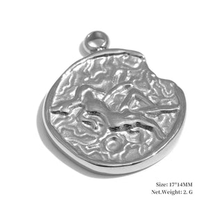 Silver pendant with engraved design on a white background