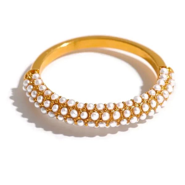 Gold-plated bracelet with rows of small white pearls on a white background