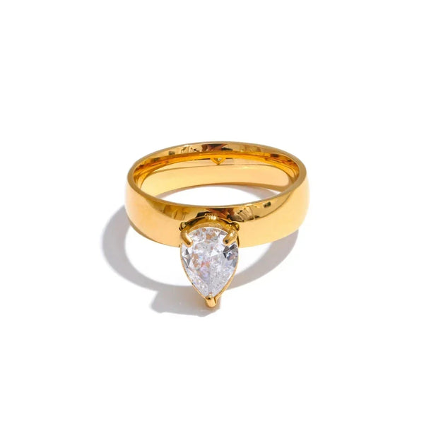 Gold ring with a pear-shaped diamond on a white background.