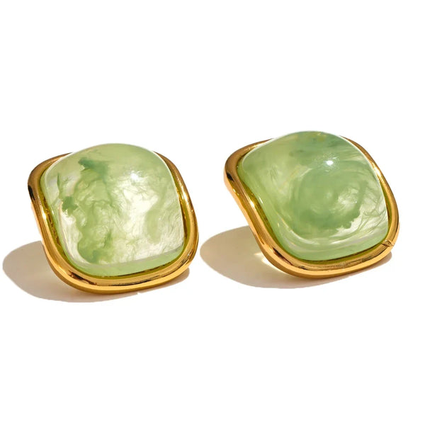 Pair of green earrings with gold frames on a white background