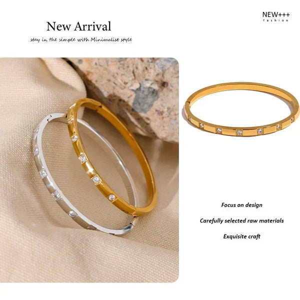 Gold and silver bangle bracelets with cubic zirconia stones on beige fabric