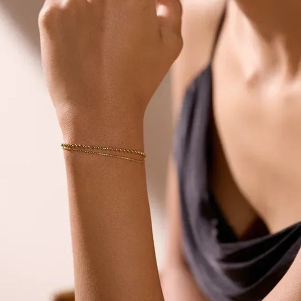 Woman wearing a delicate 18K gold-plated bracelet, elegant jewelry for women
