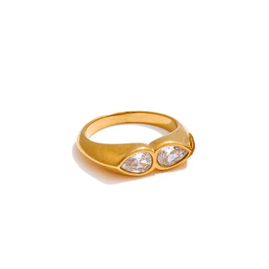 Gold ring with two clear gemstones on a white background