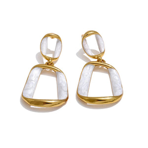 Gold and white earrings on a white background.