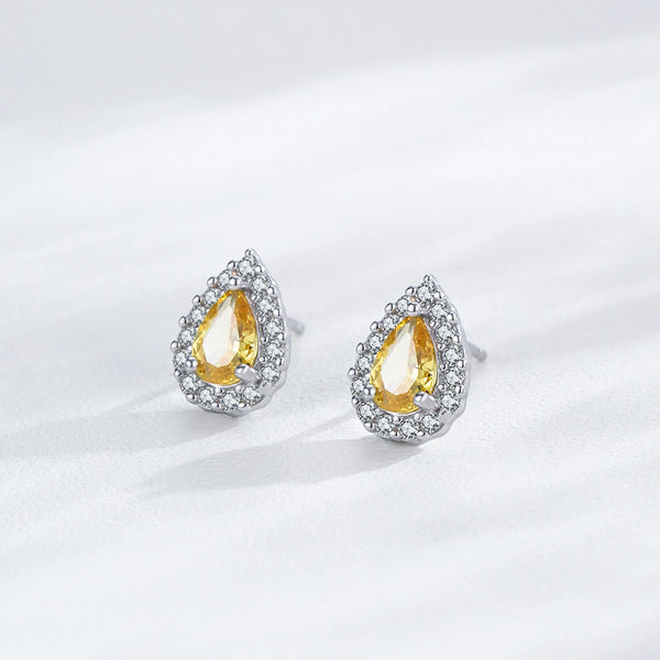 Teardrop-shaped earrings with yellow gemstones on a white background