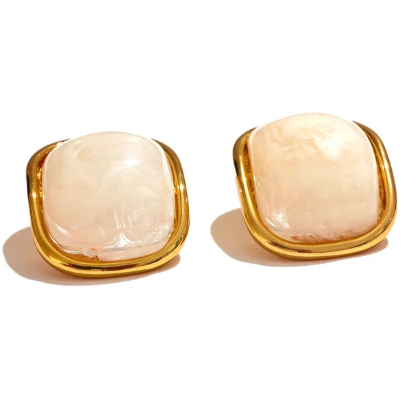 Pair of earrings with gold frames and beige stones on a white background