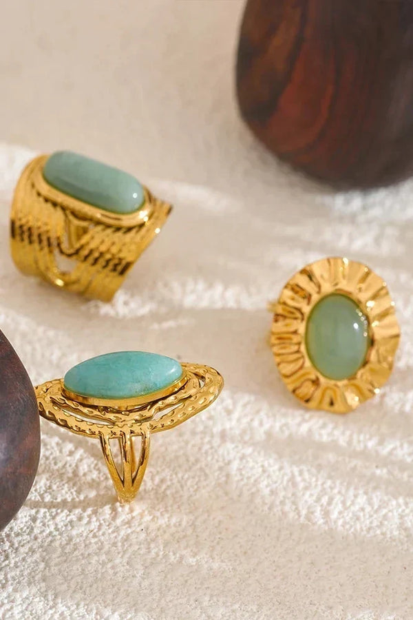 Gold rings with turquoise stones on a textured surface