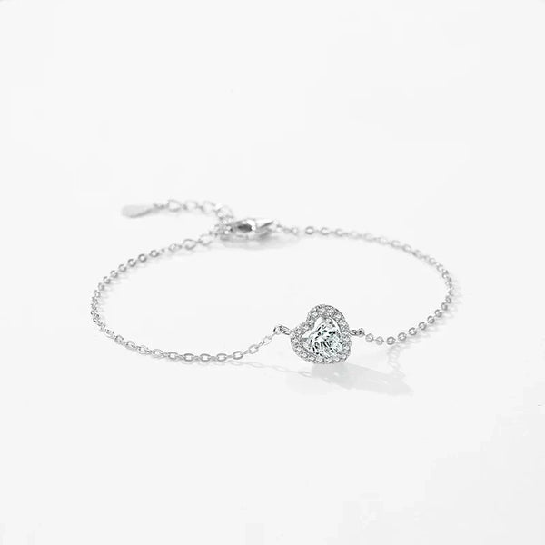Sterling silver bracelet with heart-shaped gemstone and delicate chain on white background