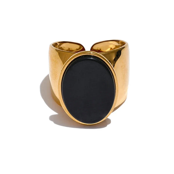 Gold ring with a black stone on a white background