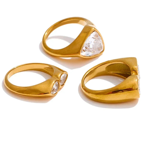 Three gold rings with gemstones on a white background